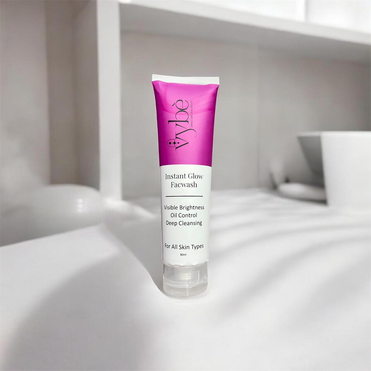 Tube of vybe Instant Glow Facewash on a white surface with a blurred background